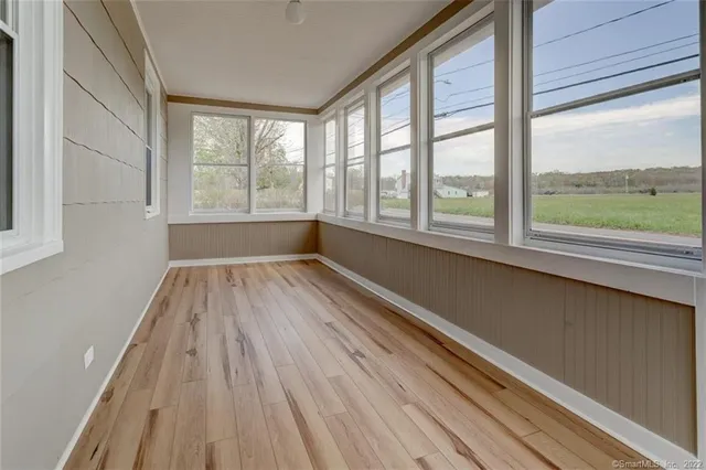 a view of a room with wooden floor and a window