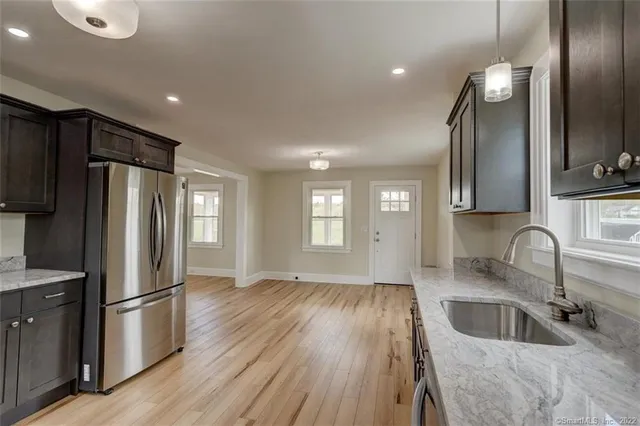a kitchen with granite countertop a refrigerator and a sink