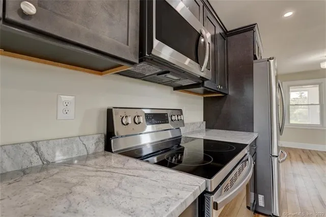 a kitchen with stainless steel appliances granite countertop a sink and a refrigerator