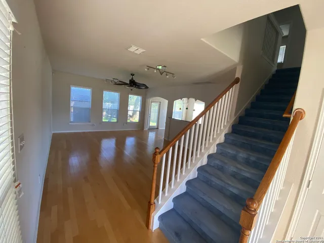 a view of a hallway with wooden floor and staircase