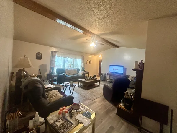 a kitchen with a sink dishwasher a kitchen island with chairs and wooden floor