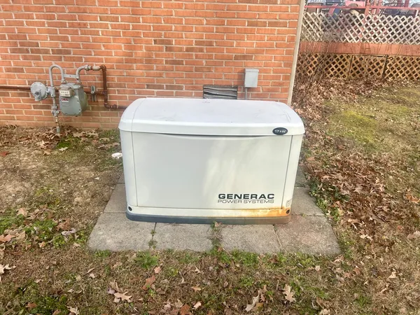 a backyard of a house with large trees and outdoor seating