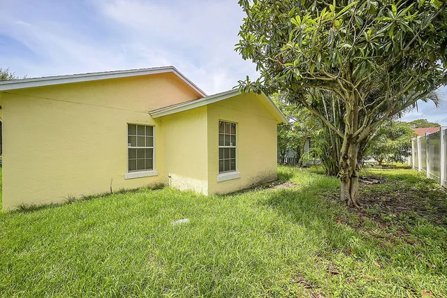 a view of a backyard with a garden and tree