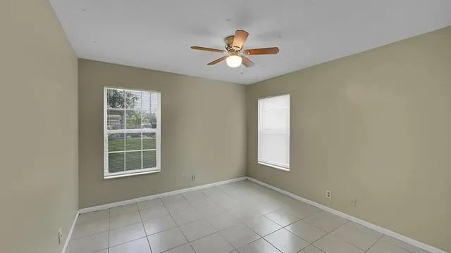an empty room with windows and fan