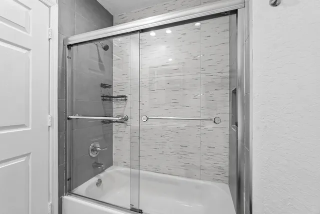 a view of an empty room with window and chandelier fan