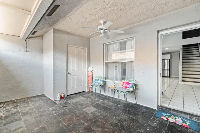 a view of an empty room and chandelier fan