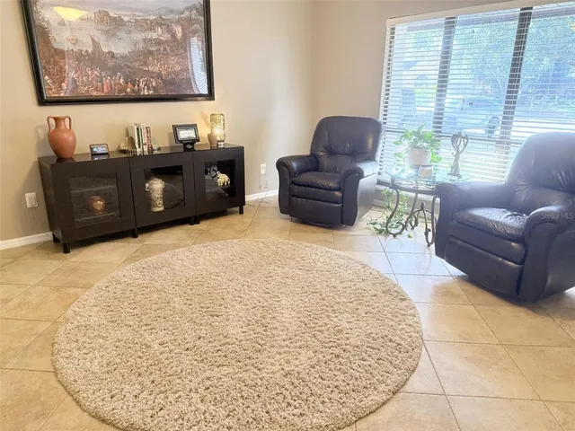 a living room with furniture a flat screen tv and a large window