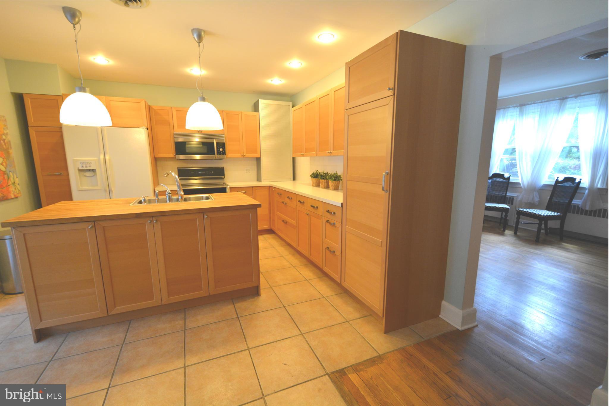 5911 Medora Road Linthicum, MD 21090 - Photo 9 of 30 a large kitchen with stainless steel appliances a large counter top a stove a refrigerator and a sink