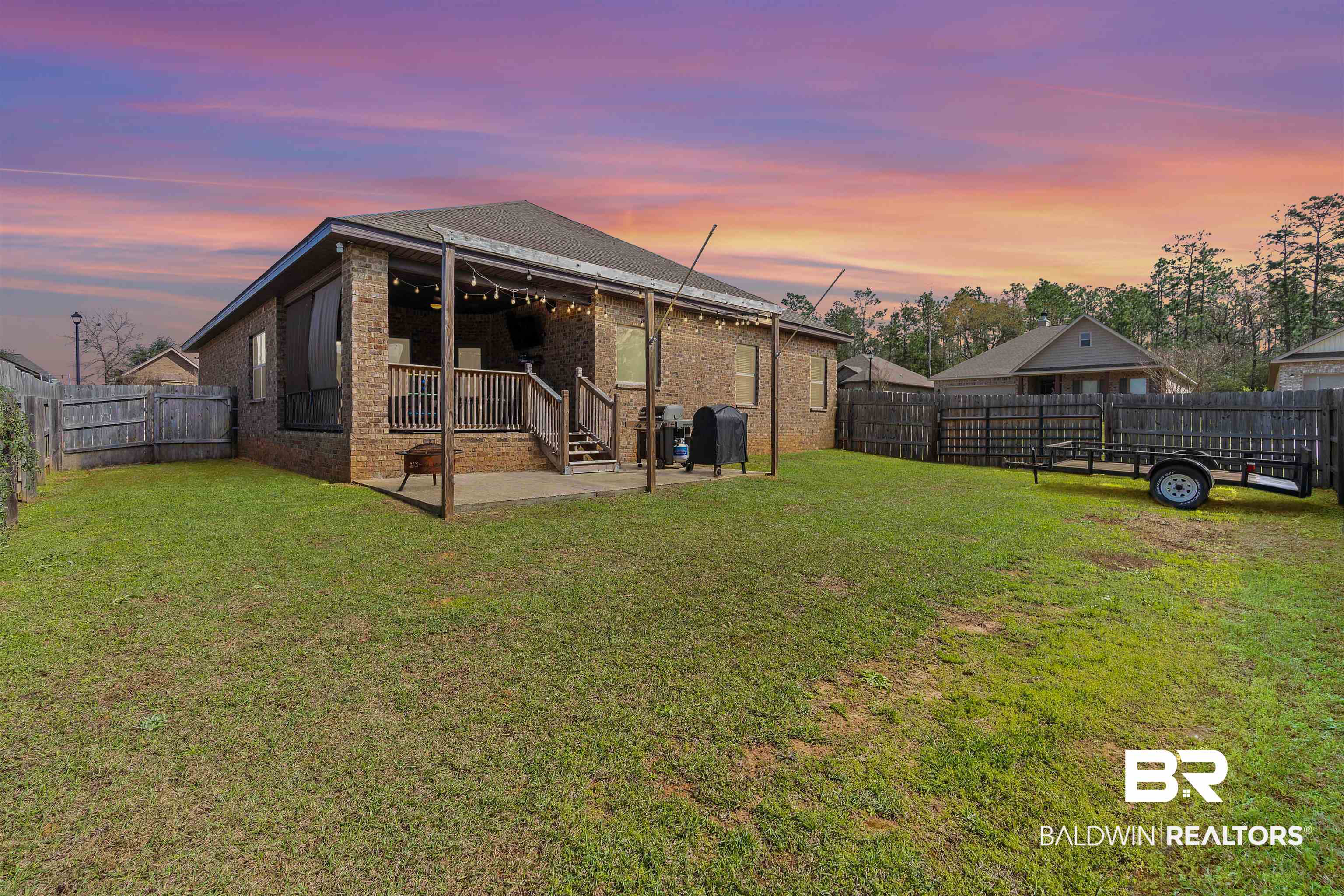 11712 Alameda Court Spanish Fort, AL 36527 - Photo 25 of 27 Back house at dusk featuring a patio and a lawn