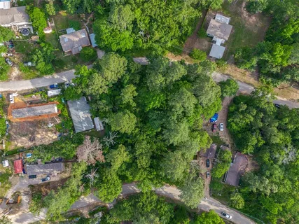 an aerial view of residential house with outdoor space and trees all around