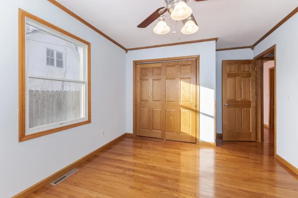 an empty room with a window and wooden floor