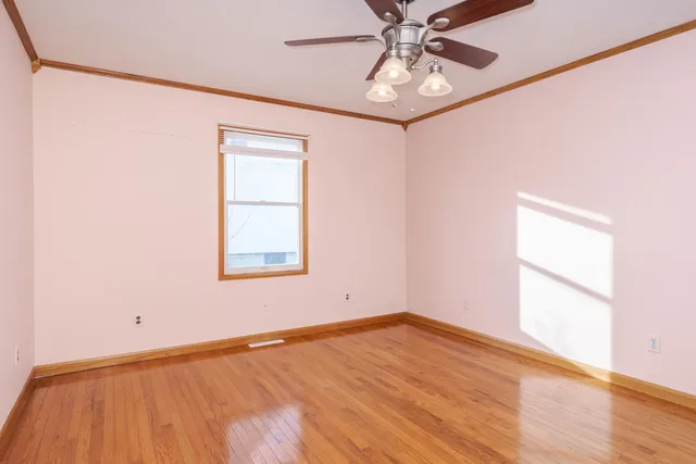 an empty room with wooden floor and door