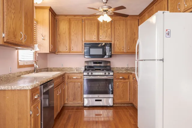 a kitchen with granite countertop cabinets stainless steel appliances and a sink