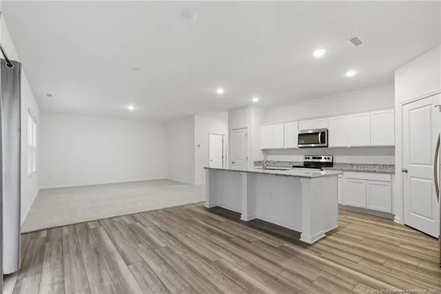 a kitchen with stainless steel appliances a refrigerator and a stove top oven