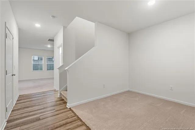 a view of a hallway with wooden floor and entryway
