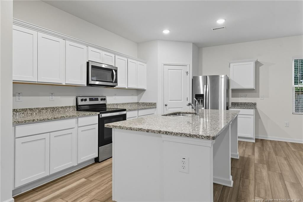 28 White Hart Court Angier, NC 27501 - Photo 10 of 36 a kitchen with stainless steel appliances granite countertop a sink stove and microwave