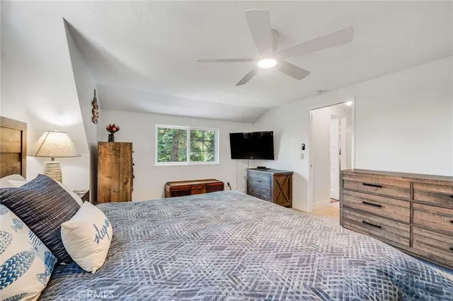 a bedroom with a bed a television and dresser