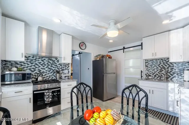 a kitchen with stainless steel appliances granite countertop a refrigerator and a stove top oven