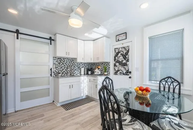 a kitchen with granite countertop white cabinets and stainless steel appliances