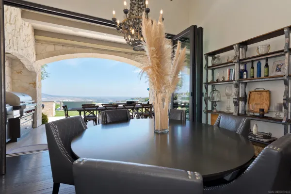 a living room with furniture a dining table and a chandelier