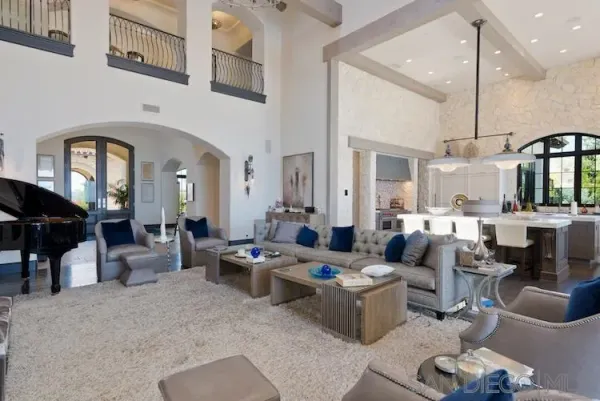 a living room with furniture kitchen view and a chandelier
