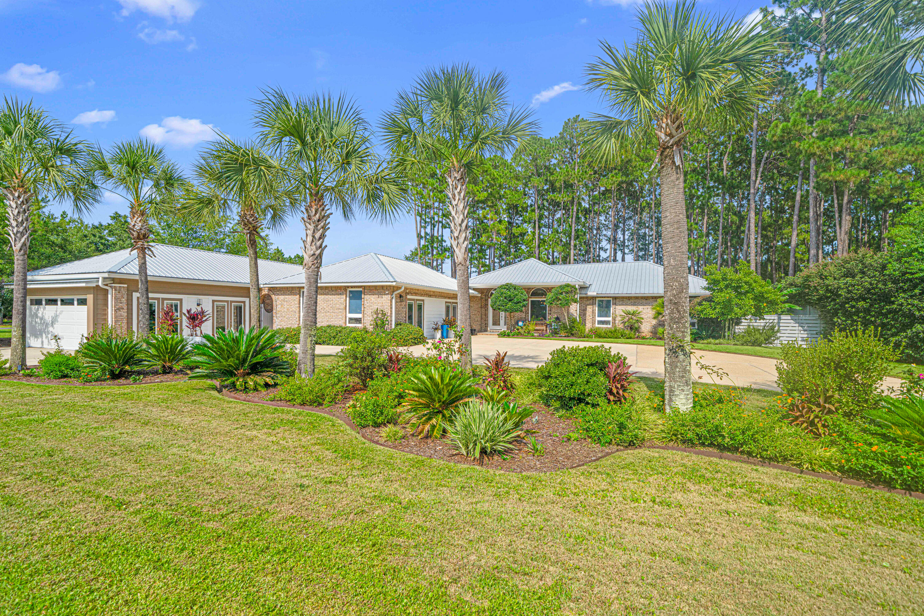 216 Santa Barbara Avenue Santa Rosa Beach, FL 32459 - Photo 3 of 85 a front view of a house with a garden