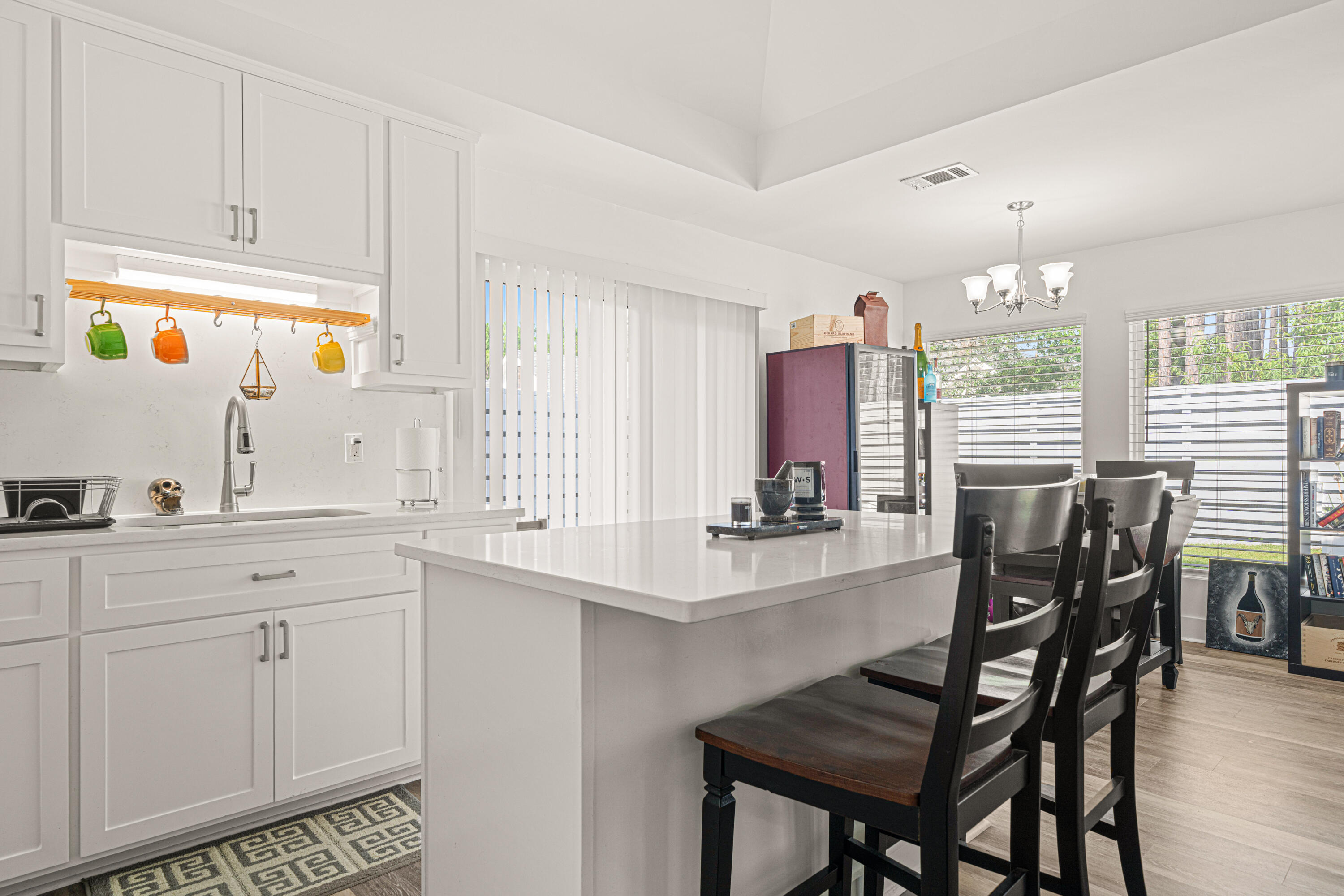 216 Santa Barbara Avenue Santa Rosa Beach, FL 32459 - Photo 74 of 85 a kitchen with stainless steel appliances kitchen island granite countertop a table chairs sink and cabinets