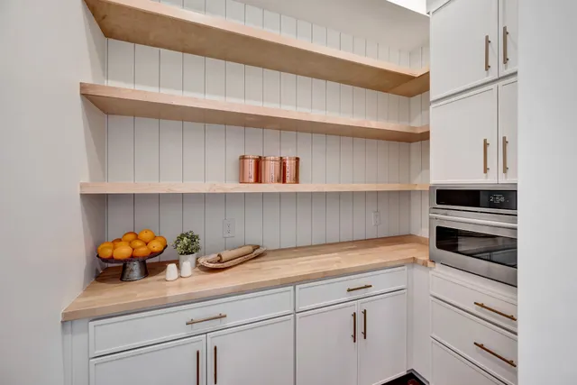 a living room with furniture large window and wooden floor