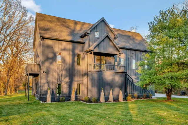 a view of a house with a big yard and large trees