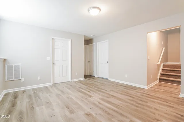 a view of an empty room with wooden floor and entryway