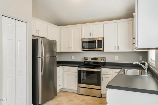 a kitchen with white cabinets and stainless steel appliances