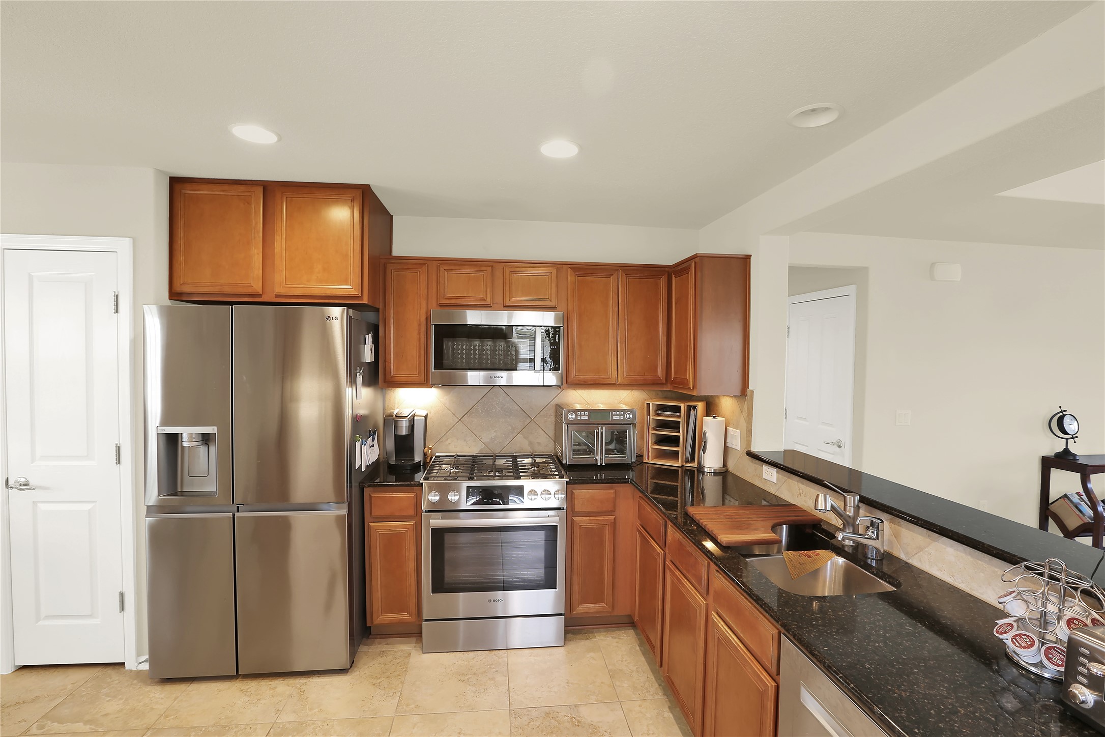 104 Sheldon Lake Drive Georgetown, TX 78633 - Photo 3 of 40 a kitchen with stainless steel appliances a refrigerator sink and microwave