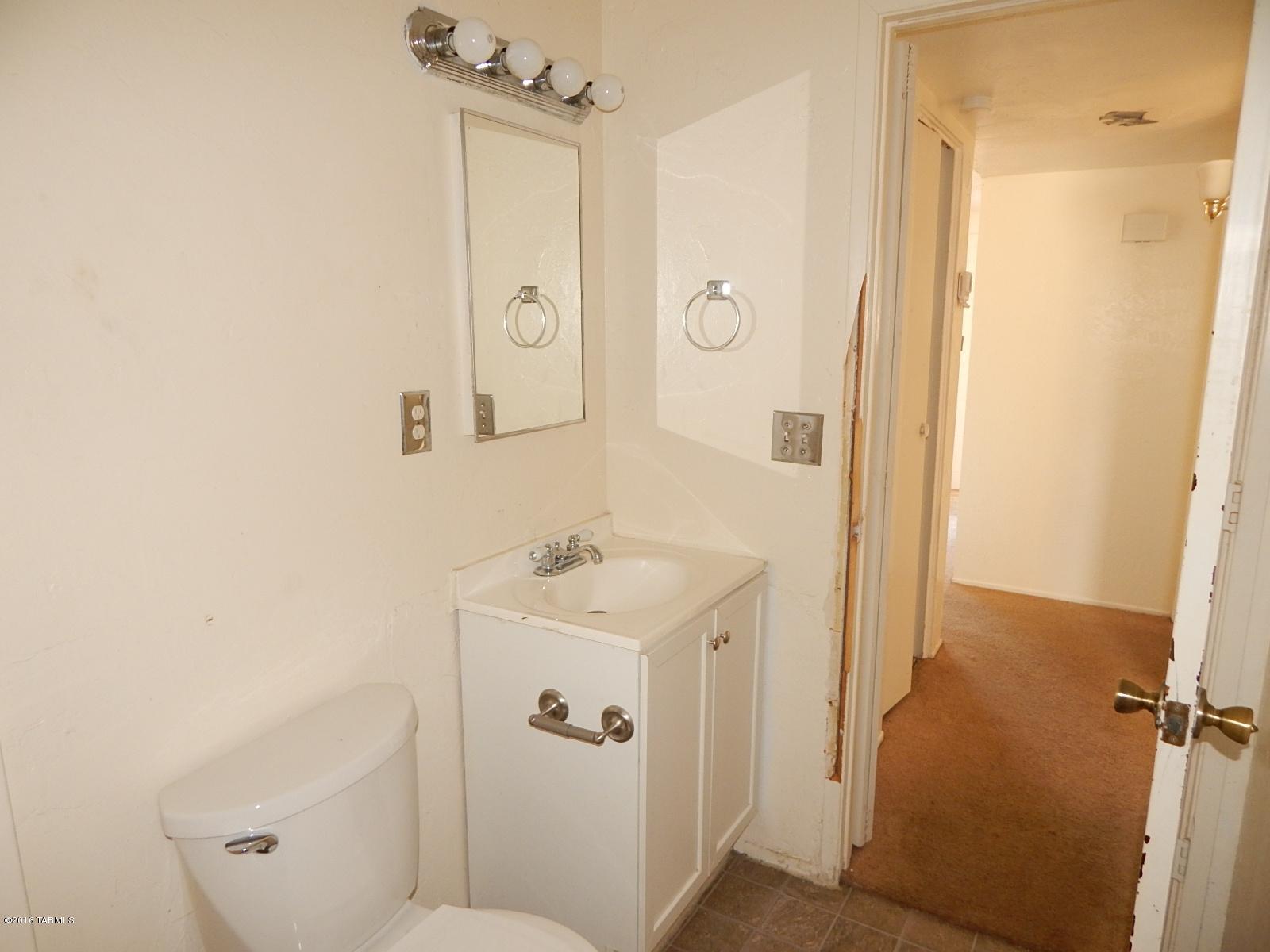 1527 West Roger Road Tucson, AZ 85705 - Photo 11 of 14 a bathroom with a sink a toilet a mirror and shower