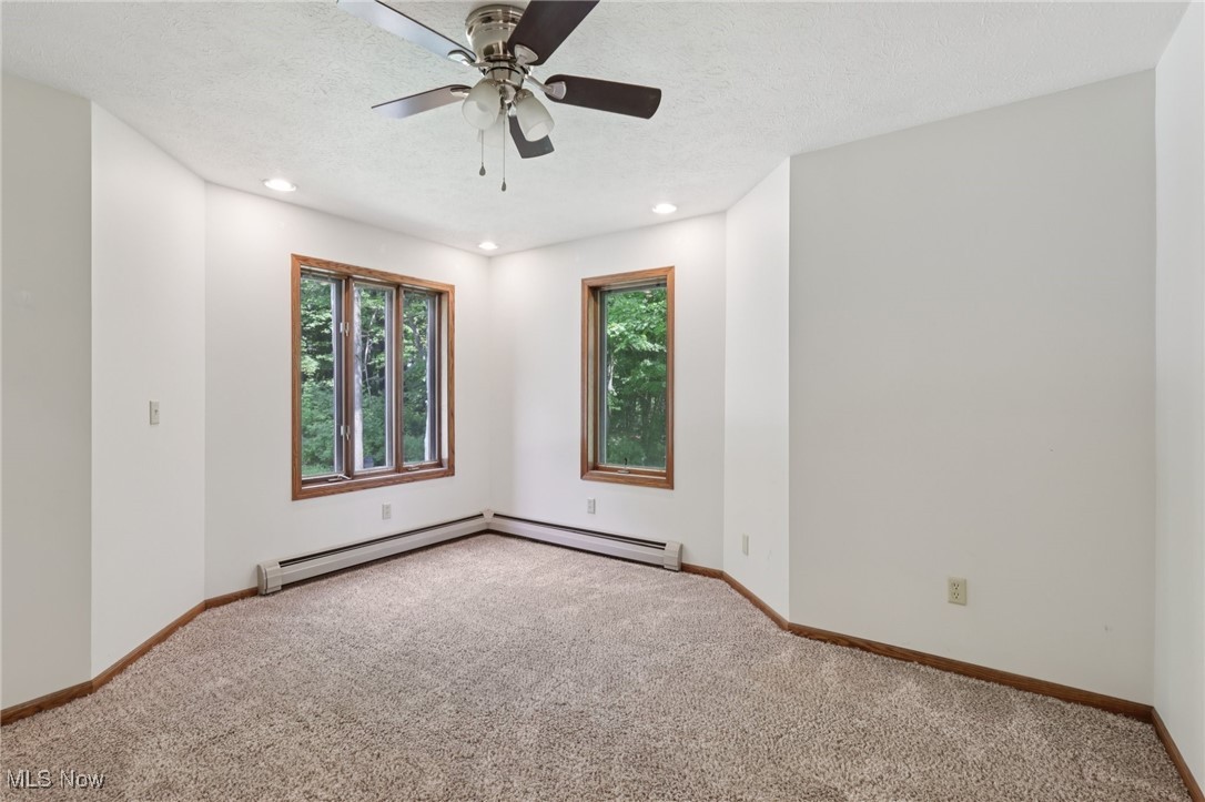 5643 Chapin Road Madison, OH 44057 - Photo 31 of 50 Carpeted empty room featuring a ceiling fan, recessed lighting, a textured ceiling, and a baseboard radiator