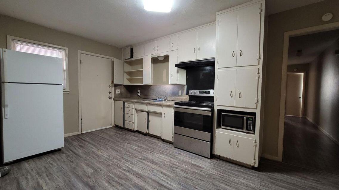 4429 31st Street Lubbock, TX 79410 - Photo 5 of 12 a kitchen with a refrigerator and a stove top oven