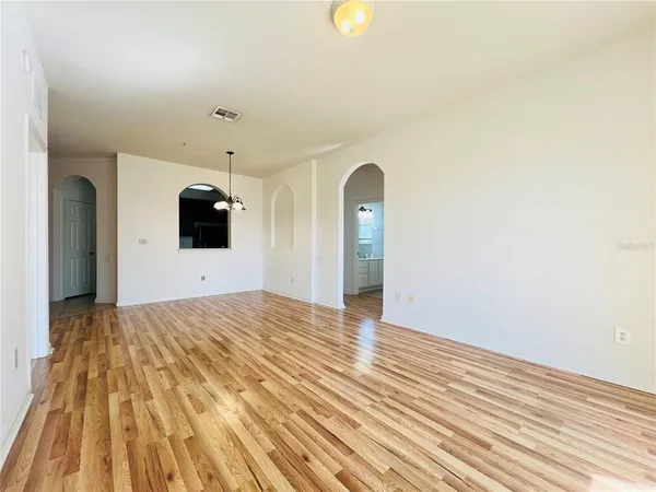 a view of a room with wooden floor and hallway