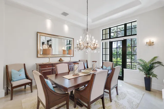 a kitchen with stainless steel appliances kitchen island granite countertop a stove a sink a refrigerator and white cabinets with wooden floor