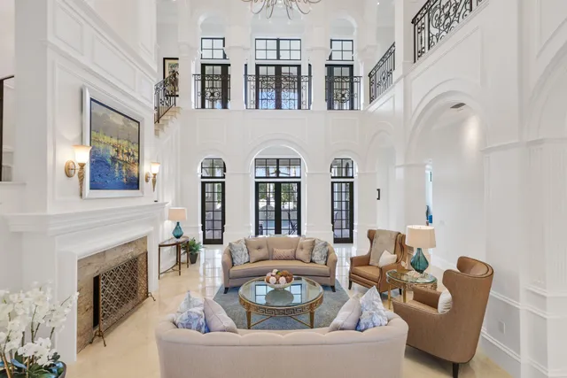 a view of a dining room and livingroom with furniture wooden floor a rug a painting and a chandelier