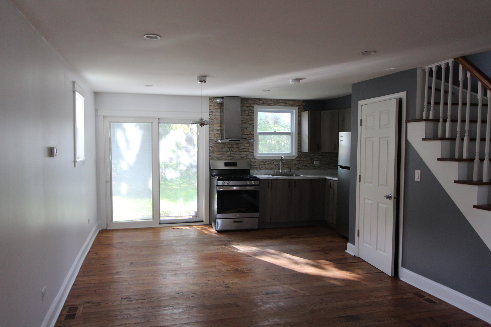 633 1/2 Whitney Boulevard Belvidere, IL 61008 - Photo 3 of 16 a kitchen with granite countertop a refrigerator a sink and dishwasher with wooden floor