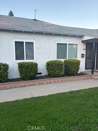 a front view of a house with garage and plants