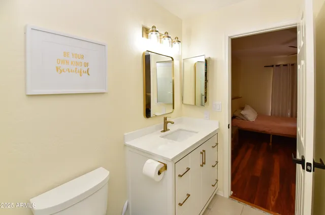 a bathroom with a sink vanity mirror and toilet