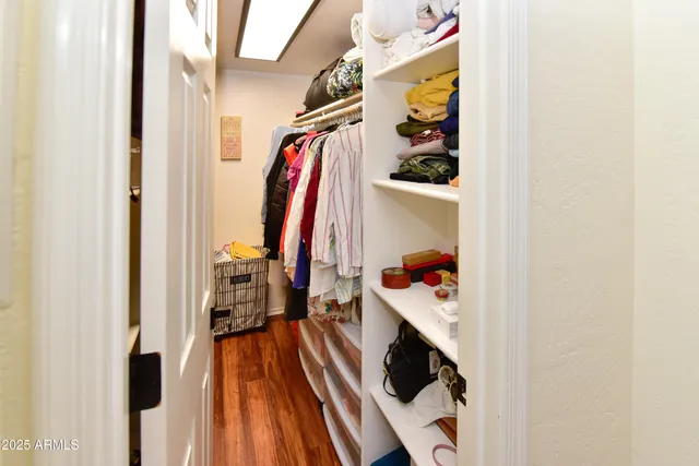 a view of walk in closet with clothes and shoes