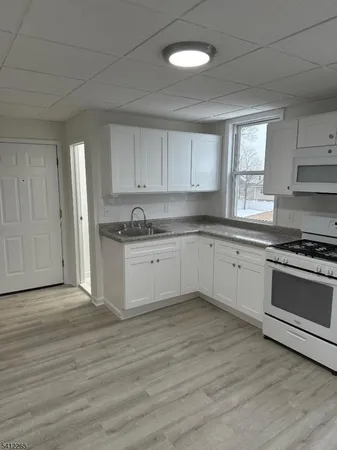 a kitchen with a white cabinets and window
