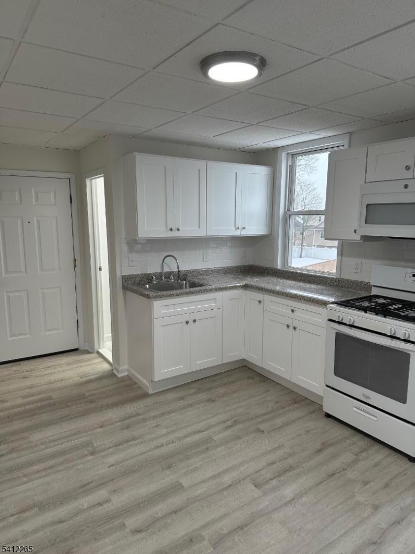 a kitchen with a white cabinets and window