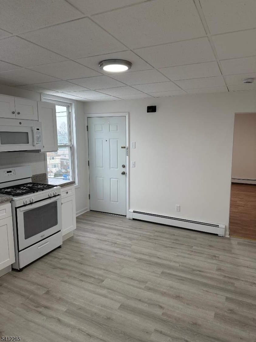 57 Harrison Street Nutley, NJ 07110 - Photo 2 of 8 a kitchen with granite countertop a stove and a refrigerator