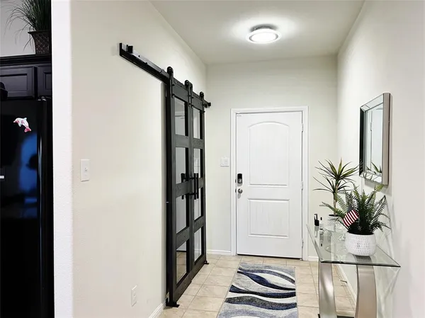 a view of a hallway with wooden floor and a potted plant