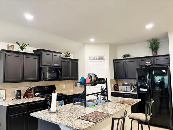 a kitchen with stainless steel appliances kitchen island granite countertop a sink and cabinets