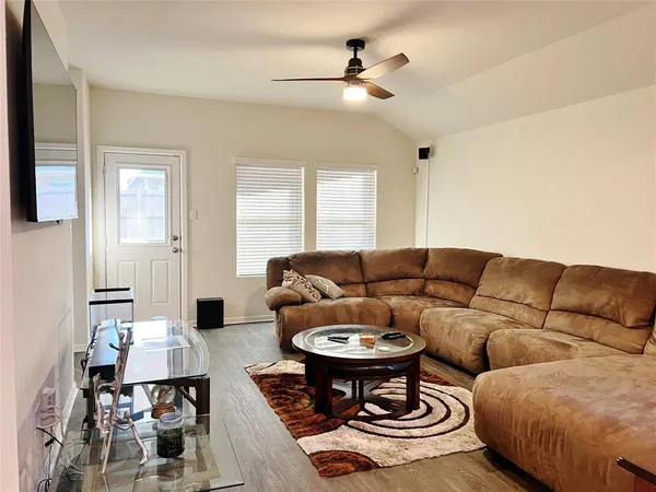 a living room with furniture and wooden floor