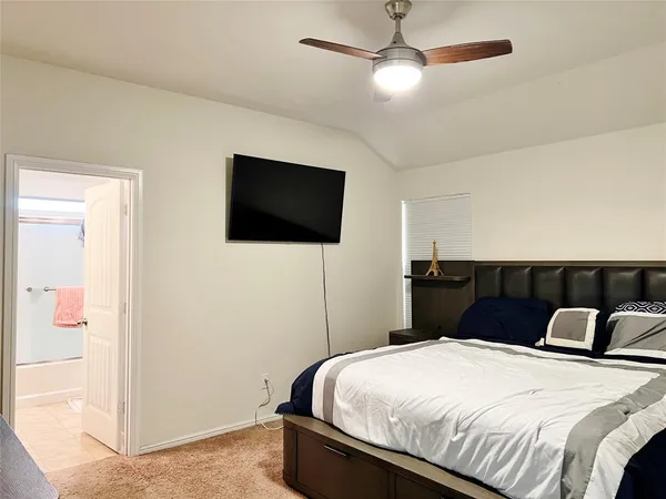 a bedroom with a bed and a flat screen tv