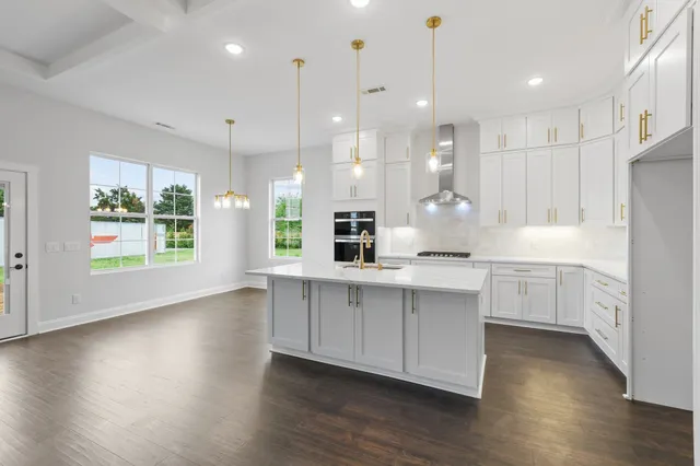 a large kitchen with a stove top oven a sink a dishwasher and a refrigerator